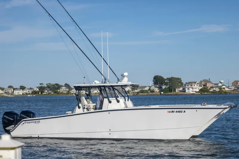 Slide: The Image of 2020 Freeman 34VH boat on water with coastal houses in background. - 9