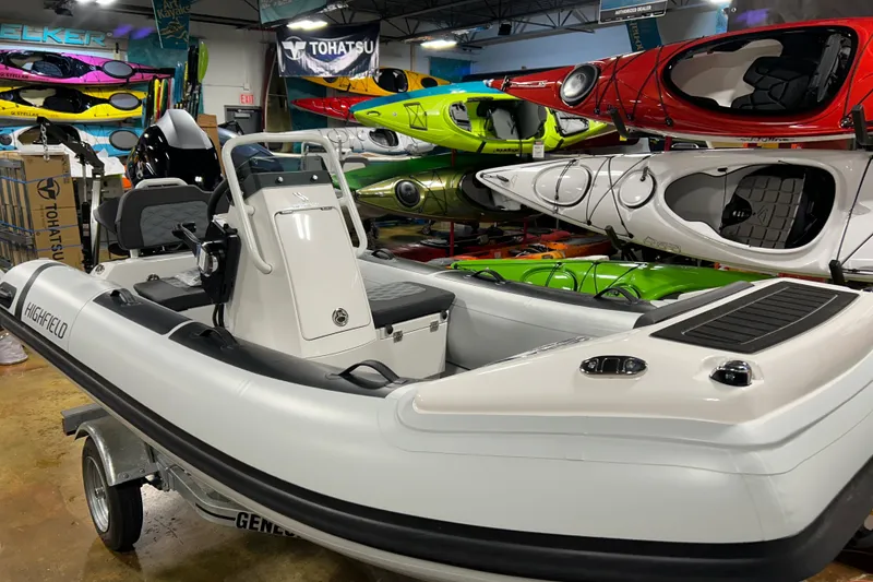 Slide: The Image of 2026 Highfield Sport 360 boat displayed in a showroom with colorful kayaks. - 3