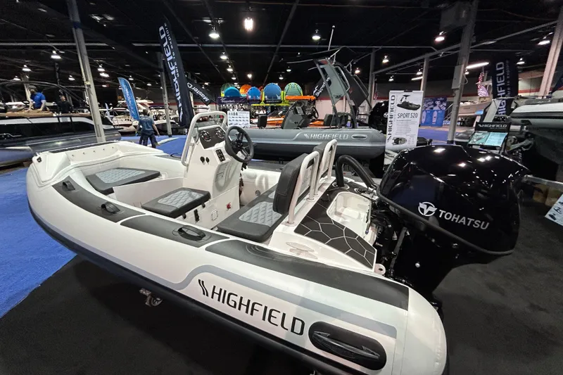 Slide: The Image of 2026 Highfield Sport 360 boat with Tohatsu engine displayed at a boat show. - 7
