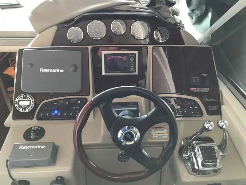 Slide: The Image of 2008 Sea Ray 330 Sundancer helm with Raymarine electronics and steering wheel. - 12
