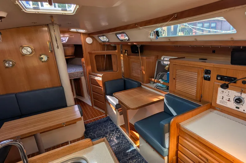Slide: The Image of Interior of a 1995 Catalina 36 MkII sailboat, featuring wood paneling and cozy seating. - 21