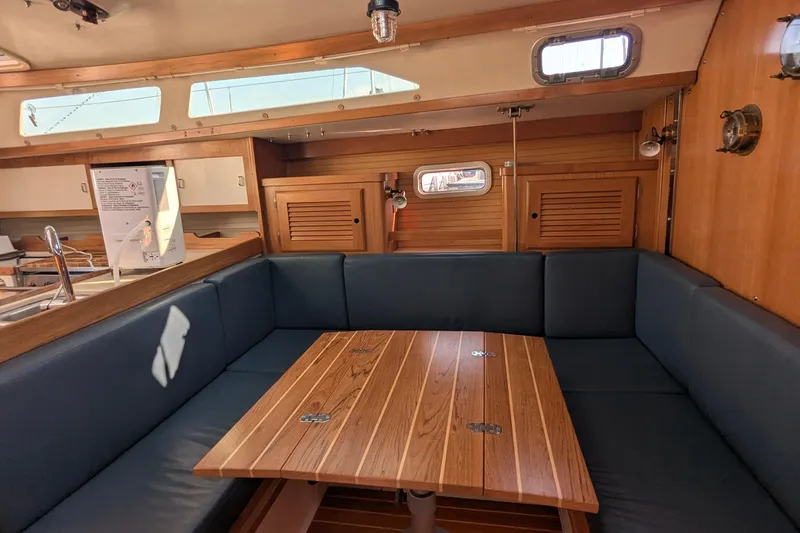 Slide: The Image of Interior of a 1995 Catalina 36 MkII sailboat with wooden table and blue seating. - 25