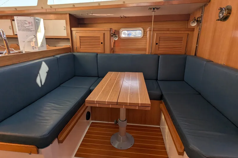Slide: The Image of Interior of 1995 Catalina 36 MkII sailboat with blue cushioned seating and wooden table. - 26