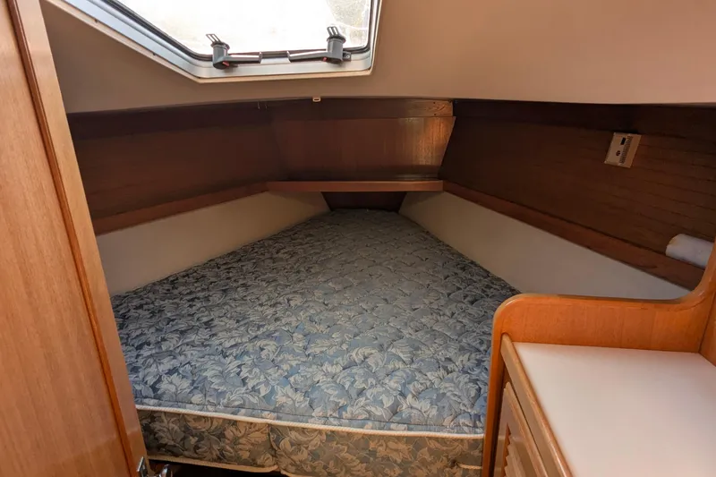 Slide: The Image of 1995 Catalina 36 MkII cabin interior with a cozy bed and wooden furnishings. - 29