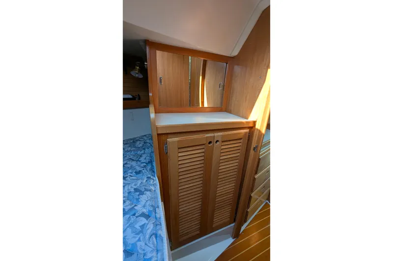 Slide: The Image of Interior of 1995 Catalina 36 MkII sailboat with wooden cabinetry and blue bedding. - 30