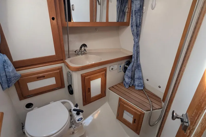 Slide: The Image of Bathroom interior of 1995 Catalina 36 MkII sailboat with sink, toilet, and wooden accents. - 33