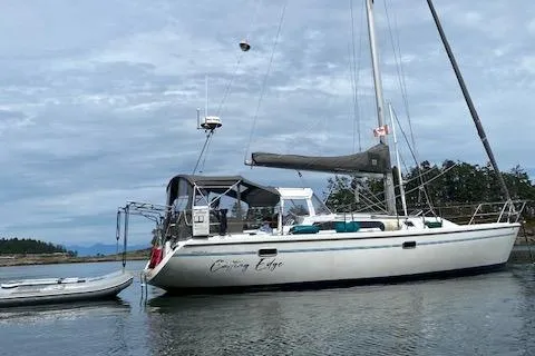 Slide: The Image of 1995 Catalina 36 MkII sailboat anchored in calm waters with a dinghy nearby. - 4