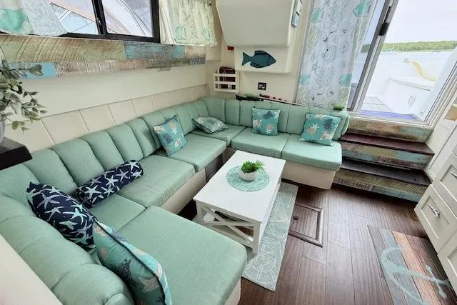 Slide: The Image of Cozy interior of 1996 Mainship 31 Sedan Bridge with teal seating and nautical decor. - 11