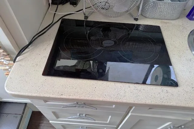 Slide: The Image of Modern induction cooktop on a Mainship 31 Sedan Bridge, 1996 model, kitchen counter. - 13