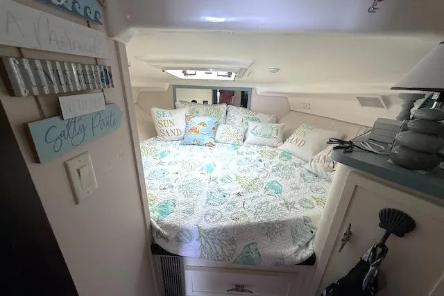 Slide: The Image of Cozy cabin interior of 1996 Mainship 31 Sedan Bridge with nautical decor and bedding. - 14