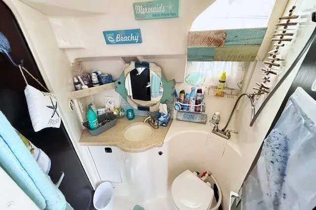 Slide: The Image of Bathroom of 1996 Mainship 31 Sedan Bridge with nautical decor and toiletries. - 15