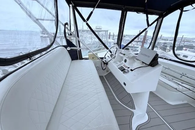 Slide: The Image of 1996 Mainship 31 Sedan Bridge helm with white seating and Garmin navigation system. - 6