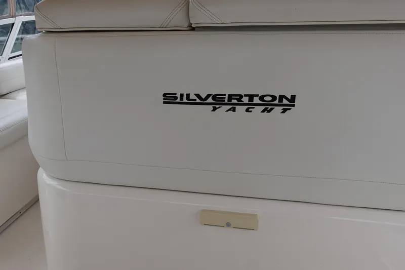 Slide: The Image of 2001 Silverton 410 Sport Bridge yacht interior with logo on white seating. - 10
