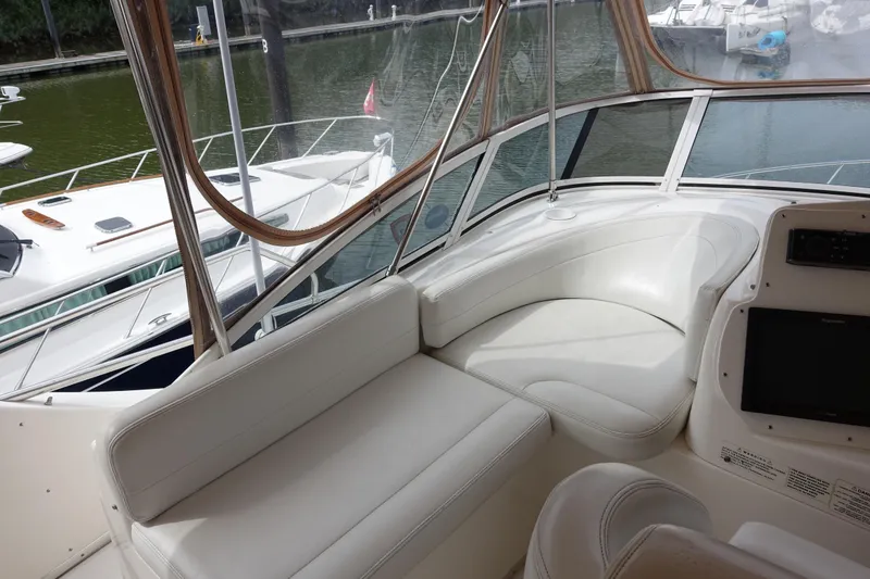 Slide: The Image of 2001 Silverton 410 Sport Bridge interior with white seating and marina view. - 13