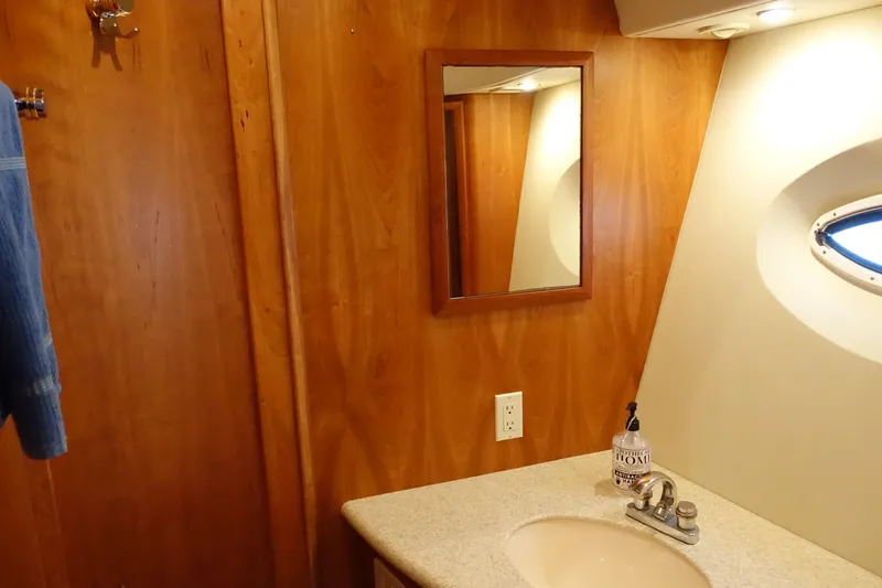 Slide: The Image of 2001 Silverton 410 Sport Bridge bathroom with wooden paneling and oval window. - 28