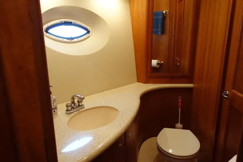 Slide: The Image of Luxurious bathroom in 2001 Silverton 410 Sport Bridge yacht with wood accents and porthole window. - 30
