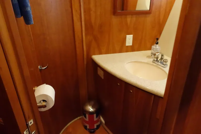 Slide: The Image of Luxurious bathroom in 2001 Silverton 410 Sport Bridge yacht with wood accents and porthole window. - 31