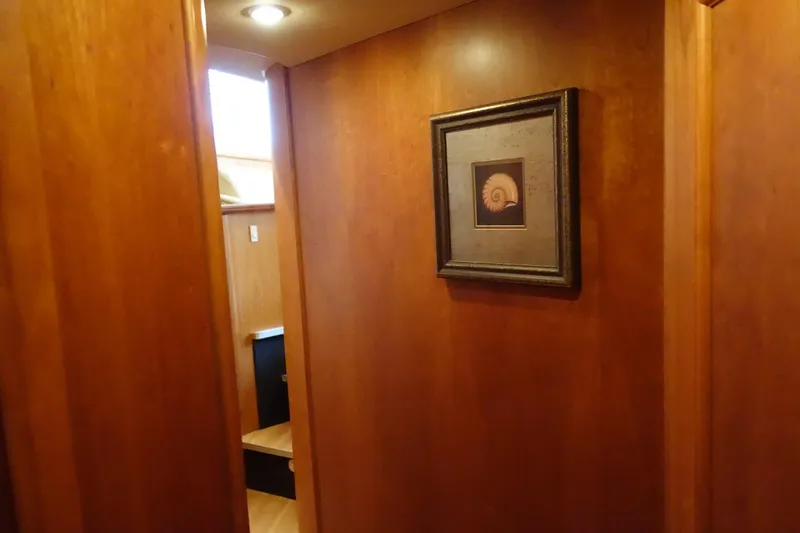 Slide: The Image of Interior hallway of 2001 Silverton 410 Sport Bridge with wooden walls and framed artwork. - 32