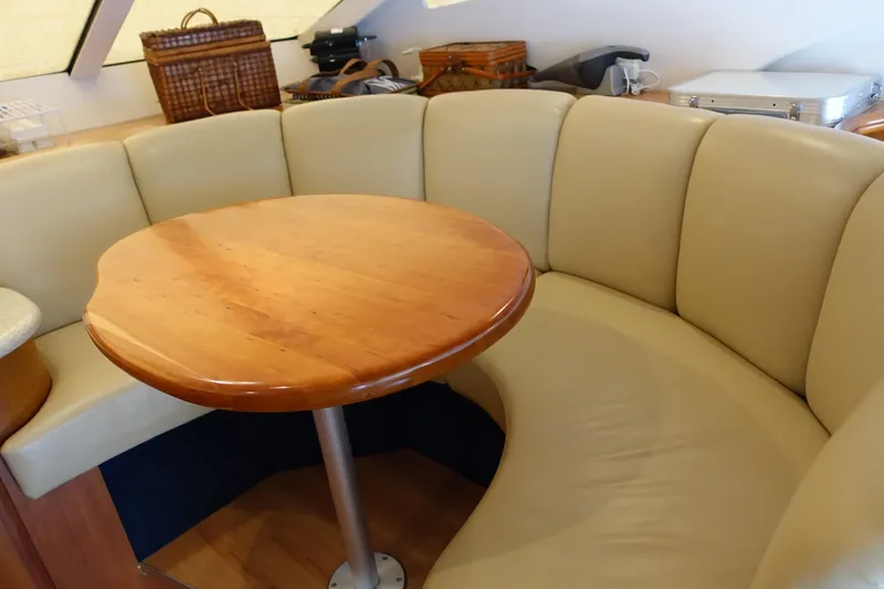 Slide: The Image of 2001 Silverton 410 Sport Bridge interior with curved beige seating and wooden table. - 35