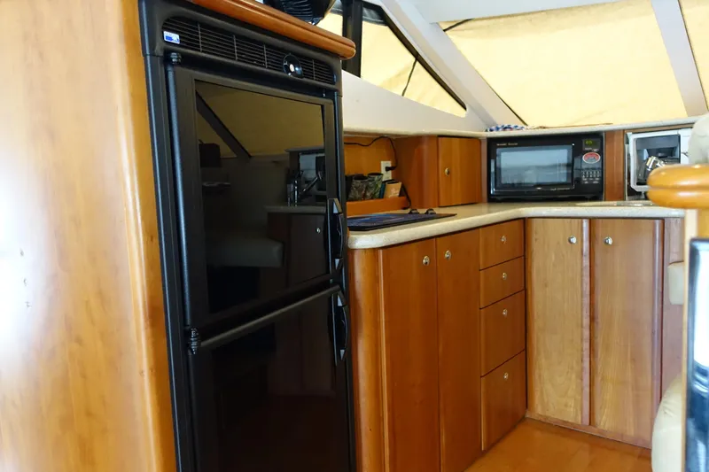 Slide: The Image of 2001 Silverton 410 Sport Bridge yacht interior kitchen with wood cabinets and appliances. - 37