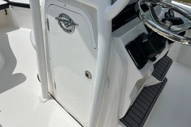 Slide: The Image of 2023 Tidewater 220 CC Adventure boat console with steering wheel and storage compartment. - 7