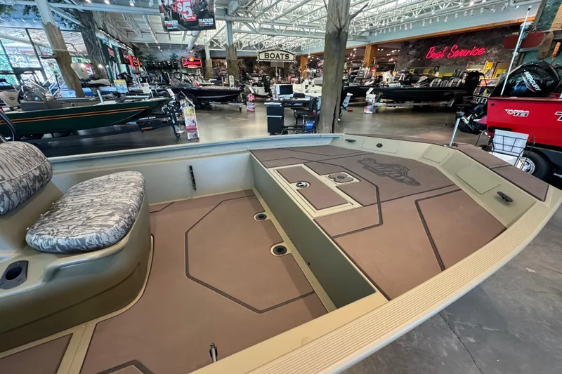 Slide: The Image of 2026 Tracker Grizzly 1860 CC boat displayed in a showroom with seating and deck features. - 4