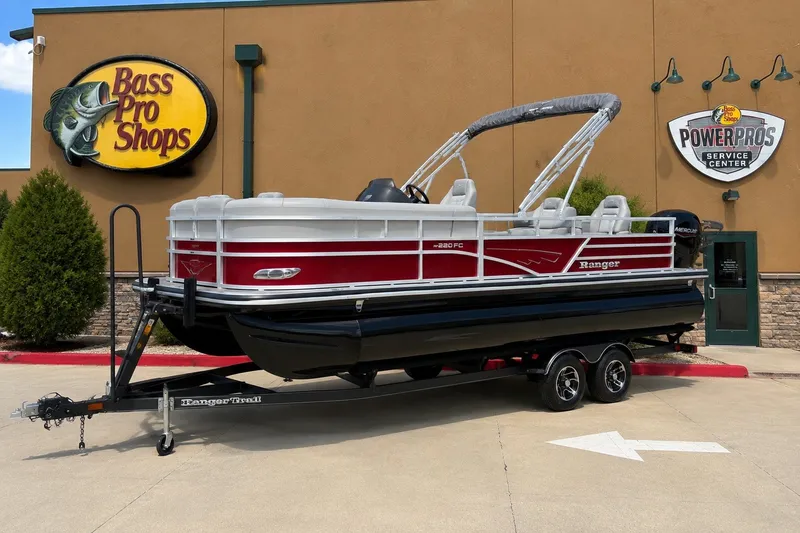 Slide: The Image of 2025 Ranger Reata 220FC pontoon boat outside Bass Pro Shops. - 1