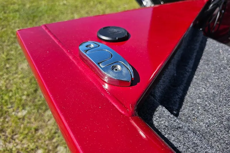 Slide: The Image of Red 2026 Tracker Pro 170 boat detail with metal latch and carpeted surface. - 17