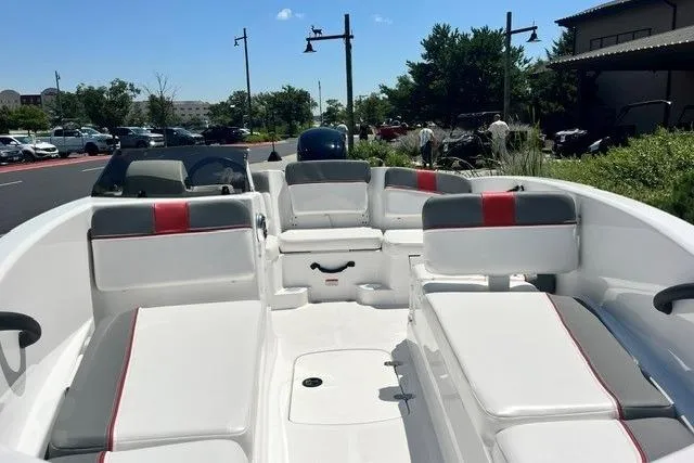 Slide: The Image of 2026 Tahoe T16 boat interior with white and red seating, parked outdoors. - 64