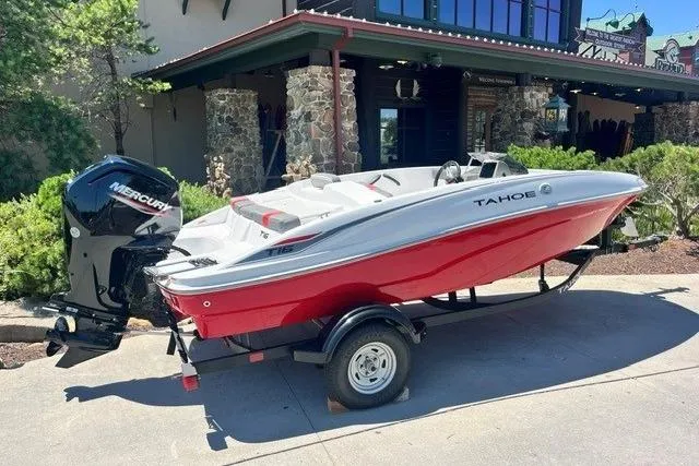 Slide: The Image of 2026 Tahoe T16 boat with Mercury engine, red and white design, parked on a trailer. - 60