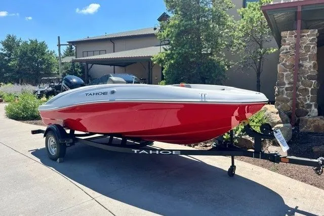 Slide: The Image of Red and white 2026 Tahoe T16 boat on trailer, parked outdoors. - 59