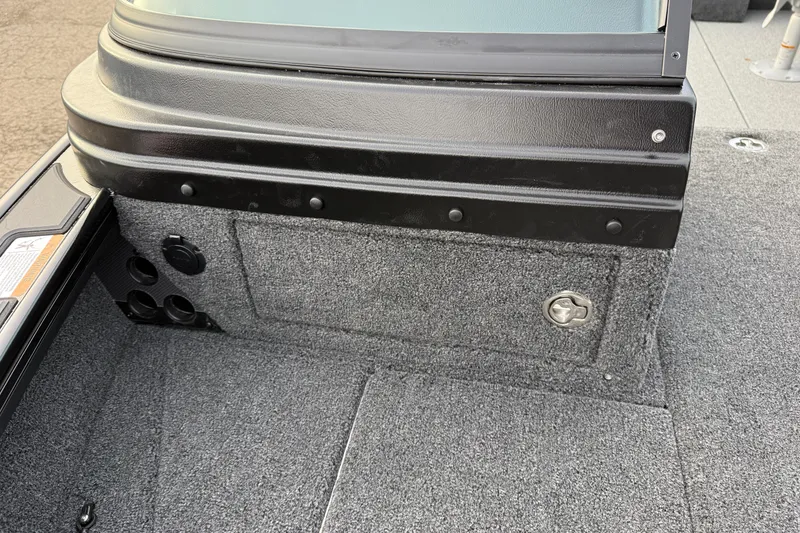 Slide: The Image of Interior view of 2026 Lund 1975 Pro-V Sport boat, featuring carpeted flooring and storage compartment. - 13