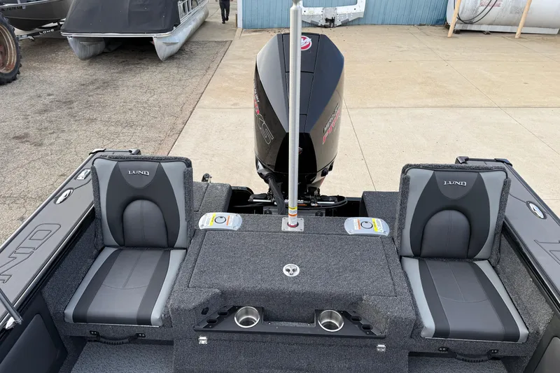 Slide: The Image of 2026 Lund 1975 Pro-V Sport boat interior with dual seats and motor, docked outdoors. - 35