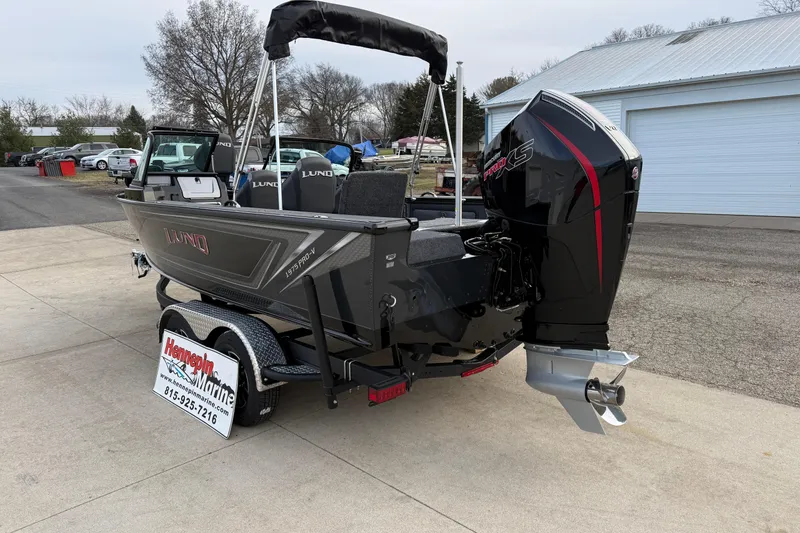 Slide: The Image of 2026 Lund 1975 Pro-V Sport boat with powerful outboard motor, parked on a trailer. - 4