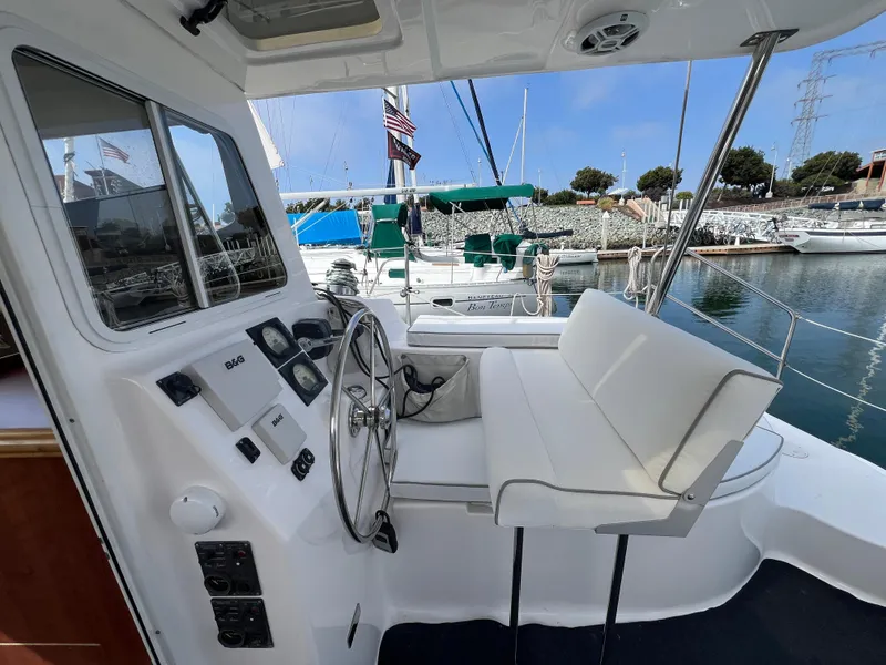 Slide: The Image of Helm of 2014 Gemini Legacy 35 catamaran with steering wheel and seating, docked at marina. - 13