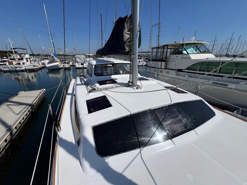 Slide: The Image of 2014 Gemini Legacy 35 catamaran docked in a marina, surrounded by other boats. - 5
