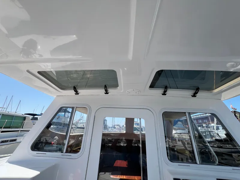 Slide: The Image of Cabin view of 2014 Gemini Legacy 35 boat with skylights and marina background. - 9