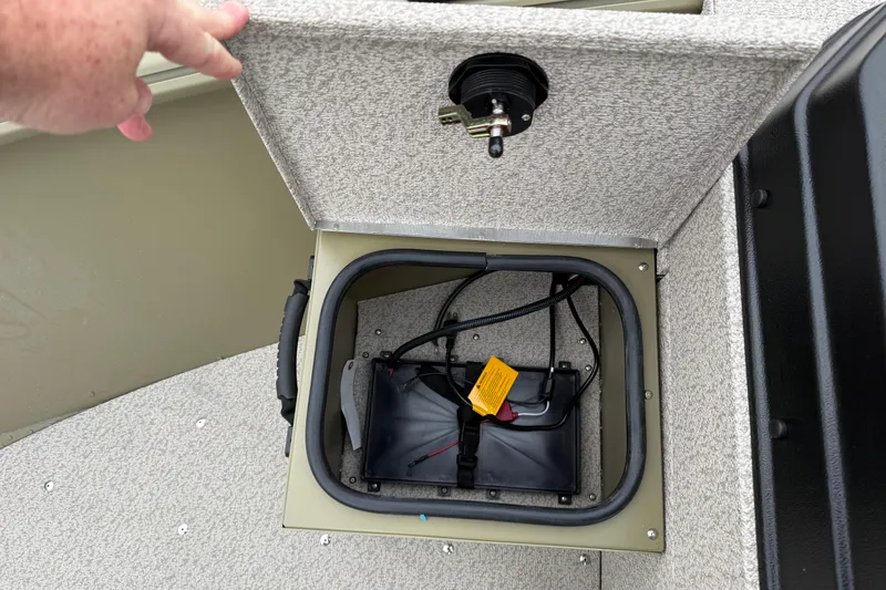 Slide: The Image of 2026 Lund 1675 Alaskan SS boat battery compartment with wiring and cover. - 16