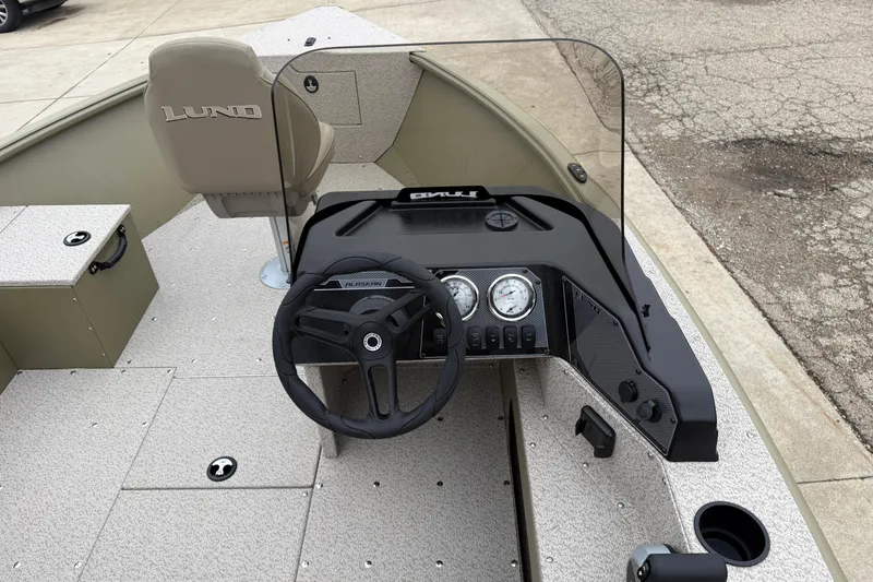 Slide: The Image of 2026 Lund 1675 Alaskan SS boat interior with steering wheel and dashboard controls. - 18