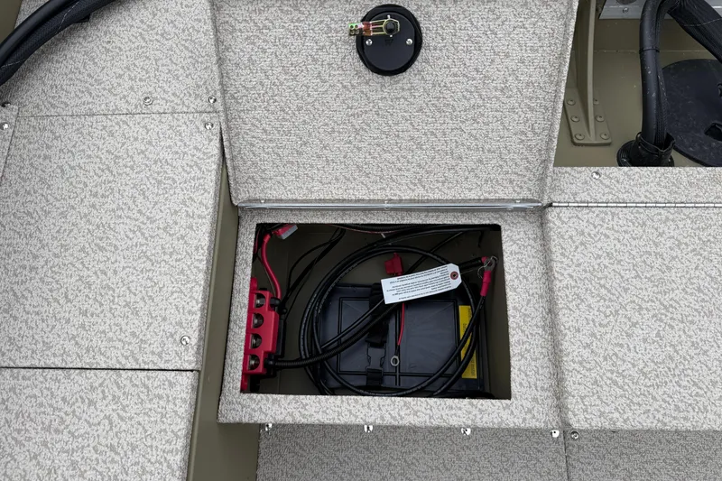 Slide: The Image of 2026 Lund 1675 Alaskan SS boat battery compartment with wiring and cover. - 23