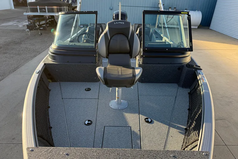 Slide: The Image of 2026 Lund 1875 Impact XS Sport boat interior with seating and windshield. - 12