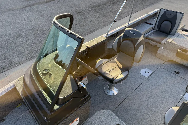 Slide: The Image of 2026 Lund 1875 Impact XS Sport boat interior with seating and windshield. - 18