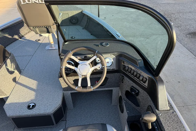 Slide: The Image of 2026 Lund 1875 Impact XS Sport boat cockpit with steering wheel and dashboard controls. - 20