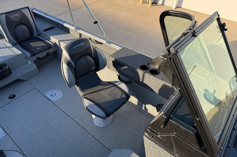 Slide: The Image of 2026 Lund 1875 Impact XS Sport boat interior with seating and windshield. - 22