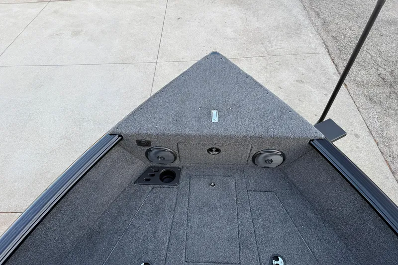 Slide: The Image of 2026 Lund 1775 Impact XS Sport boat interior, featuring carpeted deck and storage compartments. - 10