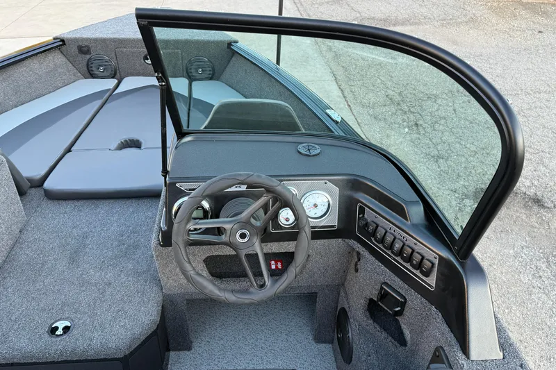 Slide: The Image of 2026 Lund 1775 Impact XS Sport boat interior with steering wheel and dashboard controls. - 16