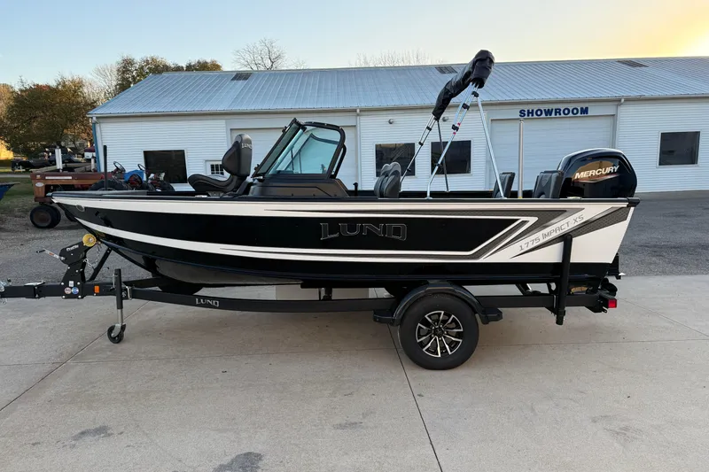 Slide: The Image of 2026 Lund 1775 Impact XS Sport boat on trailer, parked outside showroom. - 4