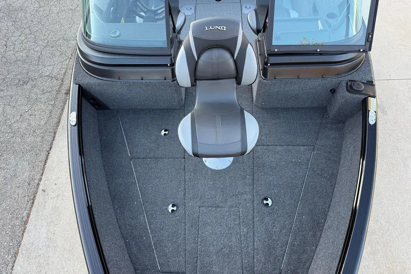 Slide: The Image of 2026 Lund 1775 Impact XS Sport boat interior with gray seating and carpeted deck. - 9