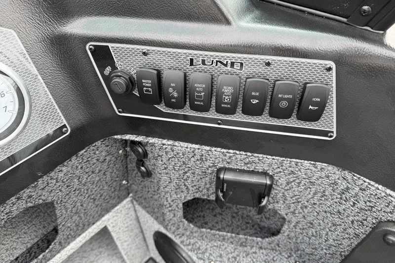 Slide: The Image of Control panel of 2026 Lund 1775 Impact XS Sport boat with various switches. - 16
