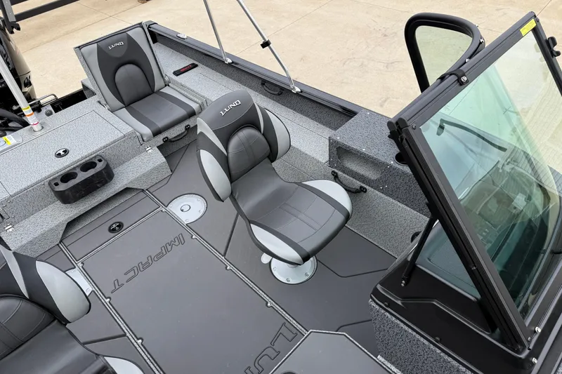 Slide: The Image of 2026 Lund 1775 Impact XS Sport boat interior with gray seating and windshield. - 18